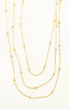 Three gold necklaces of different lengths on a white background