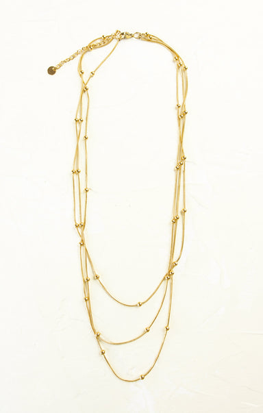 Gold necklace with multiple layers on a white background