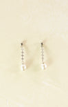 Pair of pearl earrings on a beige background