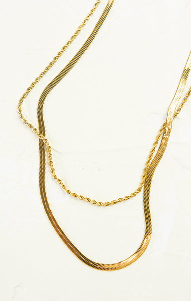 Two gold necklaces on a white background