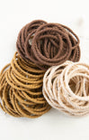 Three coiled ropes in brown, beige, and light brown on a white background