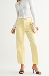 Person wearing light yellow pants and a white top on a white background