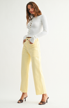 Woman wearing a white long-sleeve top and yellow pants on a white background