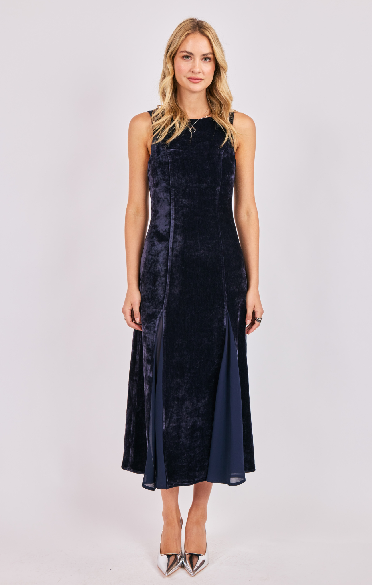Woman wearing a navy velvet dress on a white background