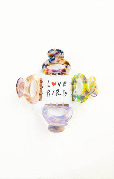 Colorful glass bird figurines with 'Love Bird' text on a white background