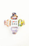 Colorful glass bird figurines with 'Love Bird' text on a white background