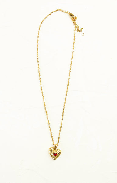 Gold necklace with a heart-shaped pendant on a white background