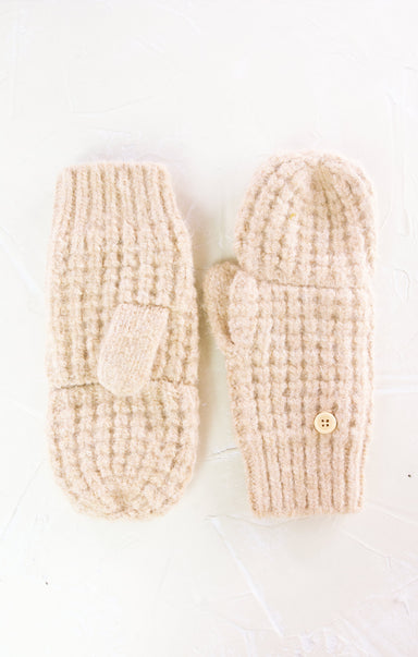 Pair of beige knitted mittens with a button on a white background
