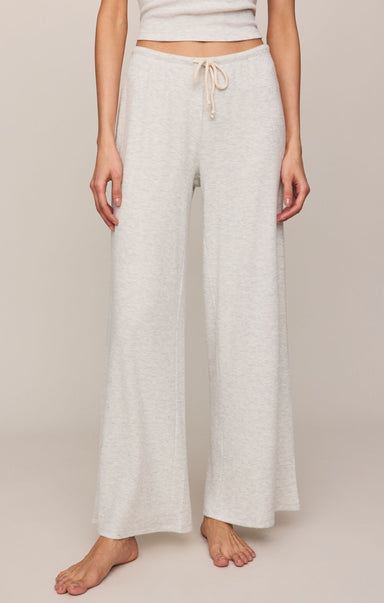 Person wearing light-colored wide-leg pants on a plain background