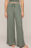 Person wearing green lounge pants on a plain background