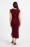 Woman wearing a burgundy dress with a subtle pattern on a white background