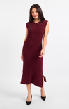 A woman modeling a sleeveless, crew-neck midi dress in deep burgundy with a textured, raised knit pattern and a side slit, paired with black pointed-toe heels against a light gray studio background.