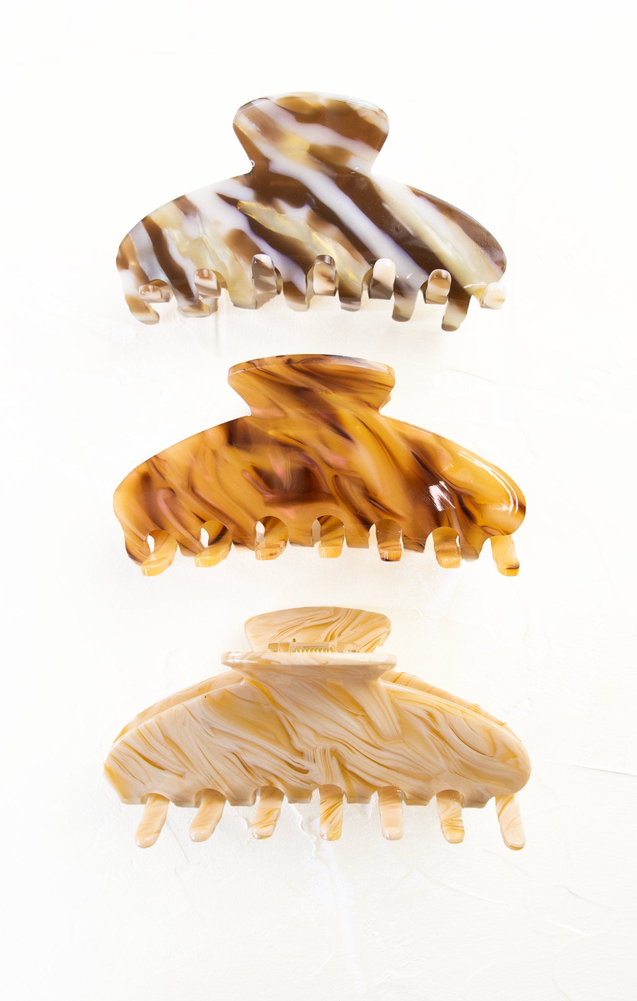 Three tortoiseshell patterned hair clips on a white background