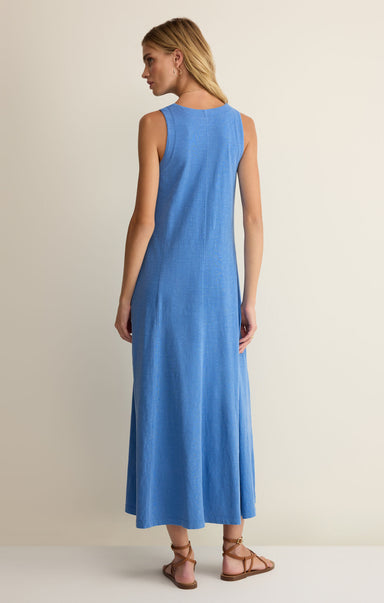 Woman wearing a blue sleeveless dress on a beige background