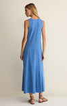 Woman wearing a blue sleeveless dress on a beige background