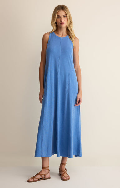 Woman wearing a blue sleeveless dress on a beige background