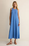 Woman wearing a blue sleeveless dress on a beige background