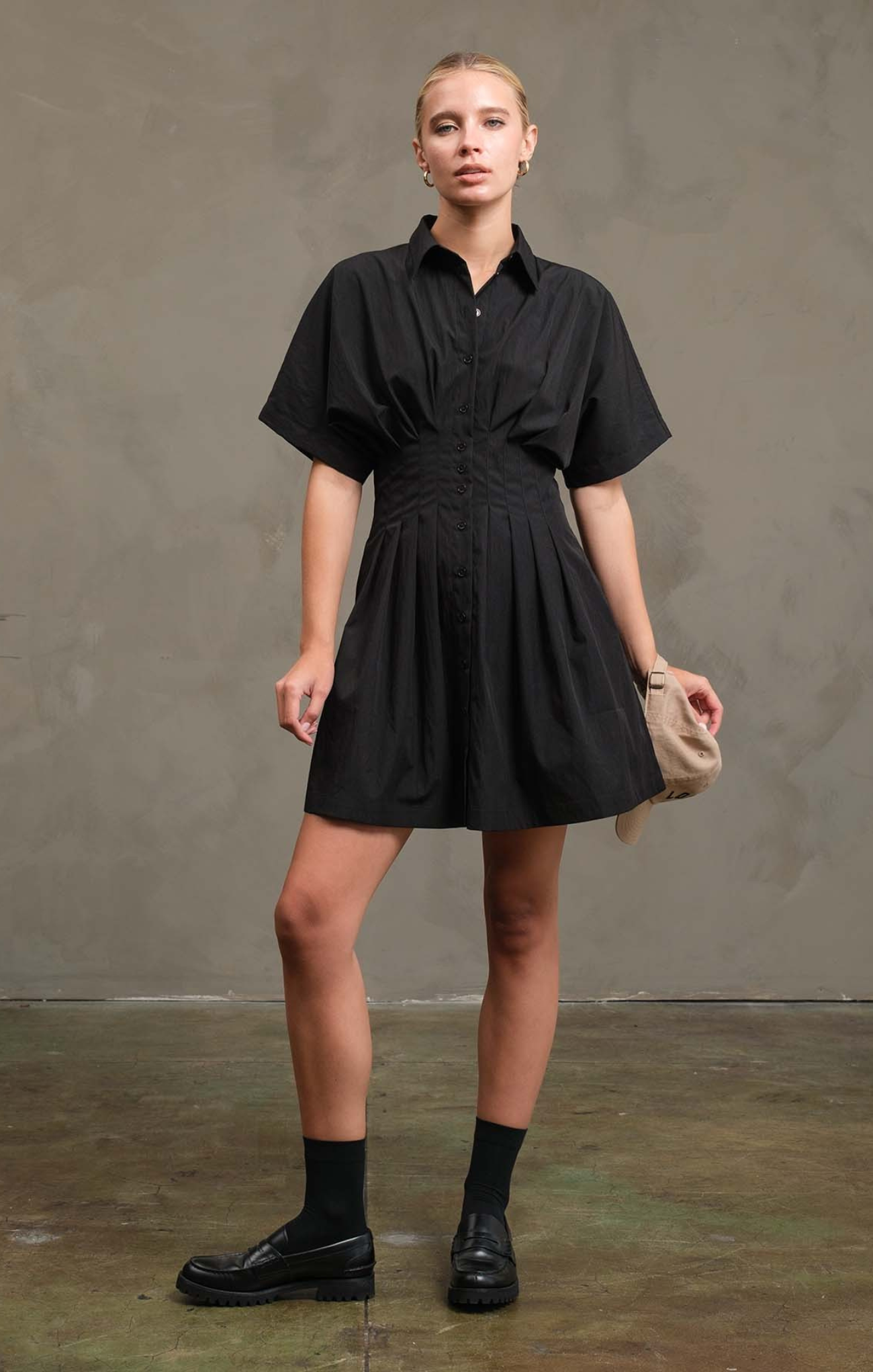 Woman wearing a black dress against a plain background