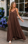 Woman in a brown dress standing in front of a coffee shop with flowers in the background