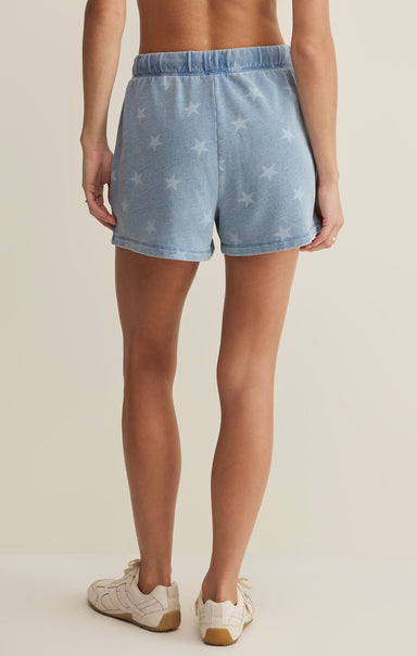 Denim shorts with star pattern worn by a person on a neutral background