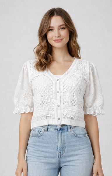 Woman wearing a white lace top and blue jeans on a plain background