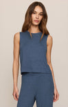 A woman modeling a sleeveless knit top and matching pants in a heathered slate blue color, set against a plain beige studio background.