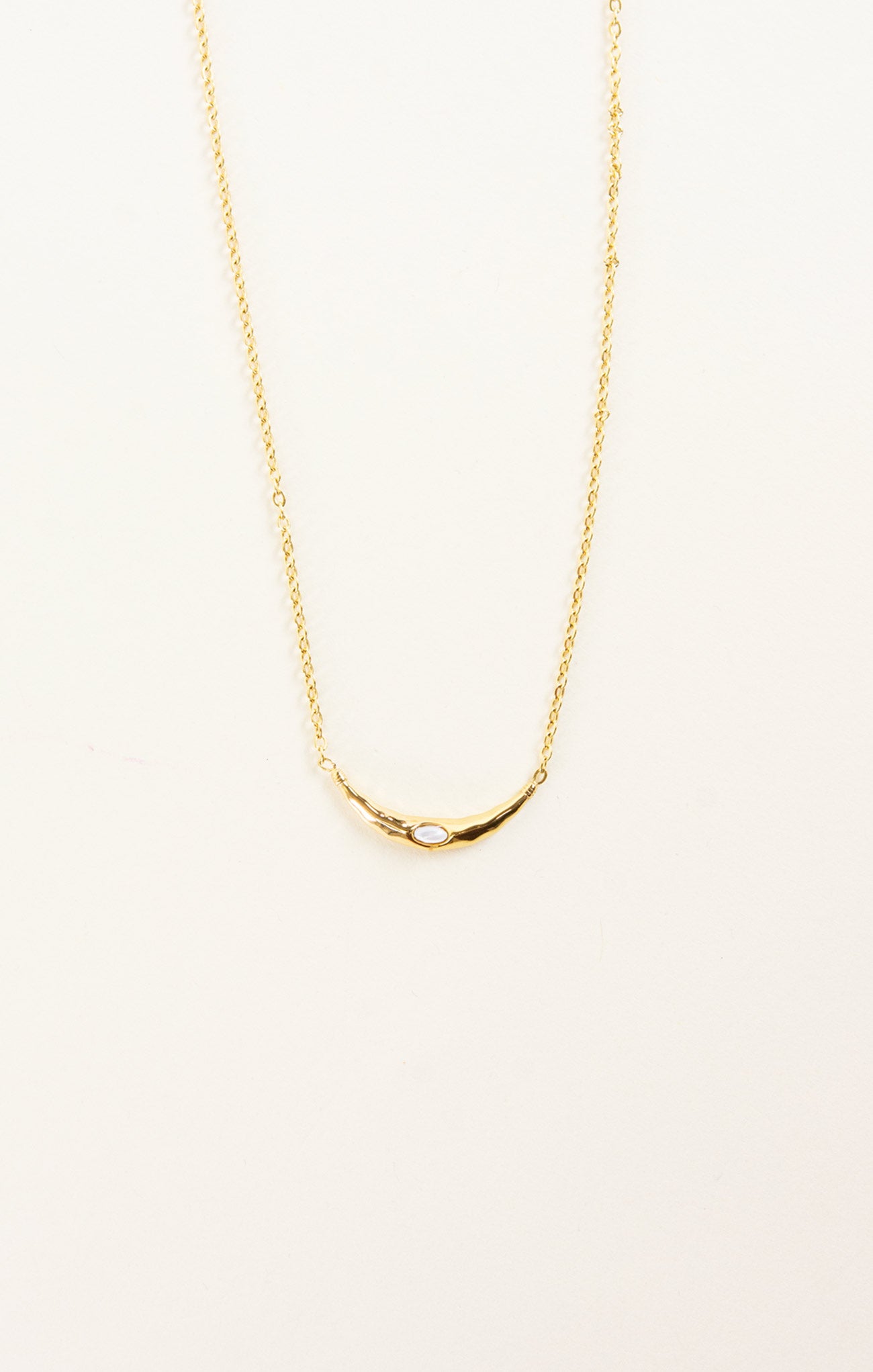 Gold necklace on a light beige background