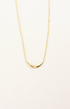 Gold necklace on a light beige background