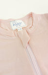 Close-up of a baby pink garment with a label on a white background