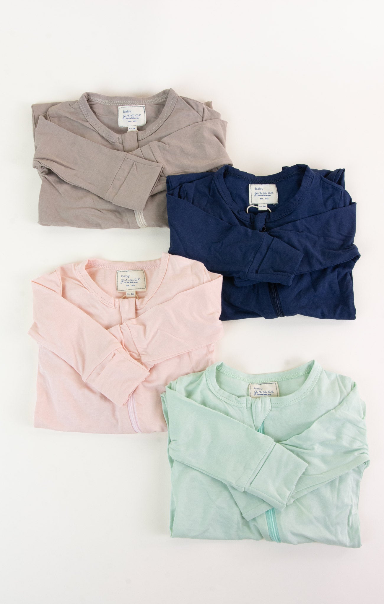 Four folded shirts in different colors on a white background