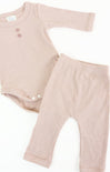 Baby romper and pants set in ribbed pink fabric on a white background