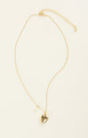 Gold necklace with a heart pendant on a beige background