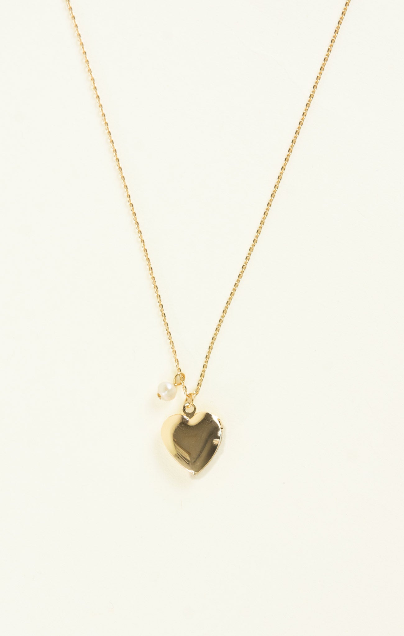 Gold necklace with a geometric pendant on a white background