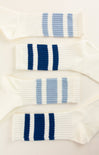 Three pairs of socks with blue and white stripes on a light background