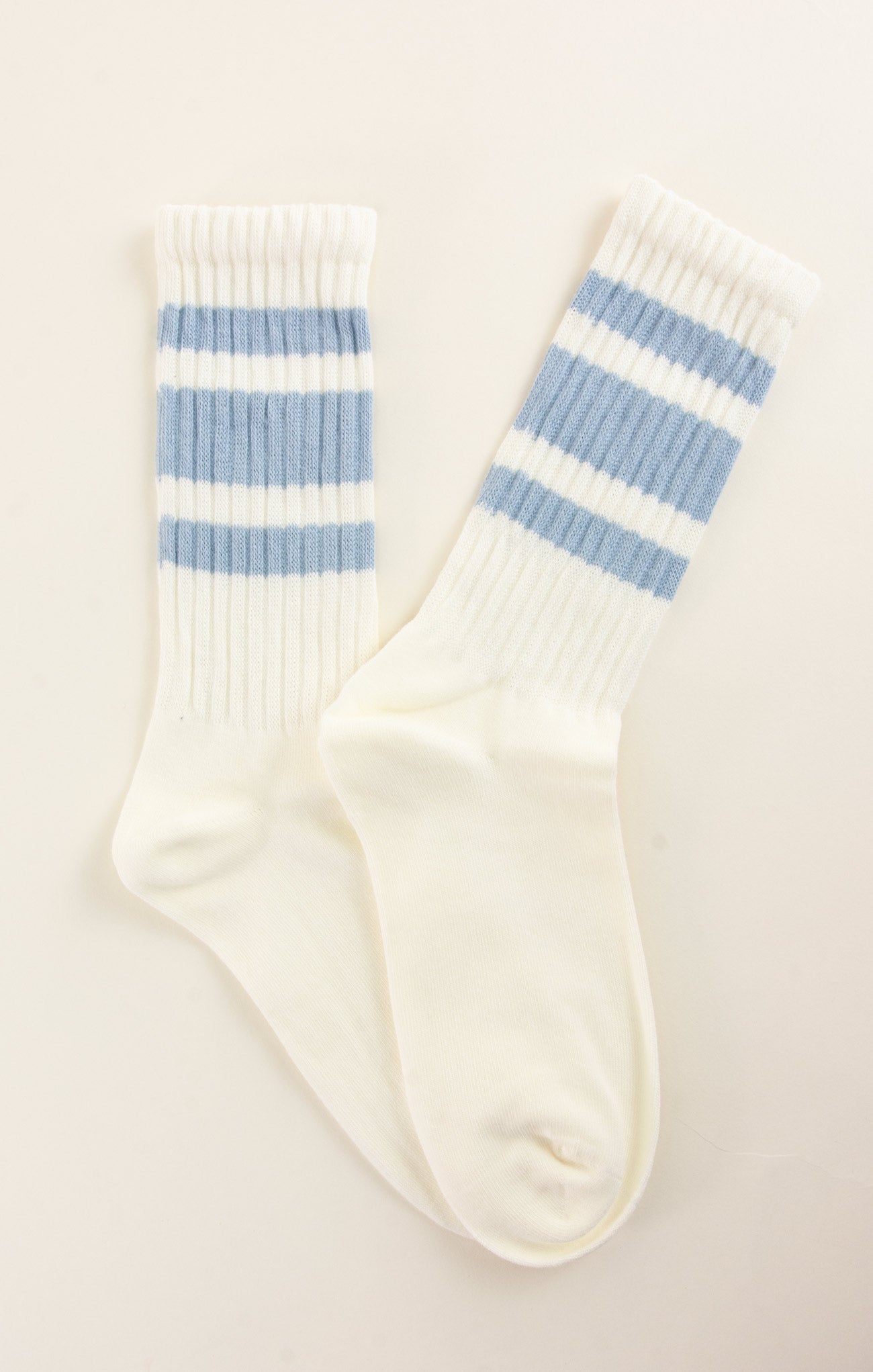 White socks with blue stripes on a light beige background