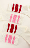 Close-up of a white sweater with red and pink striped patterns on a white background