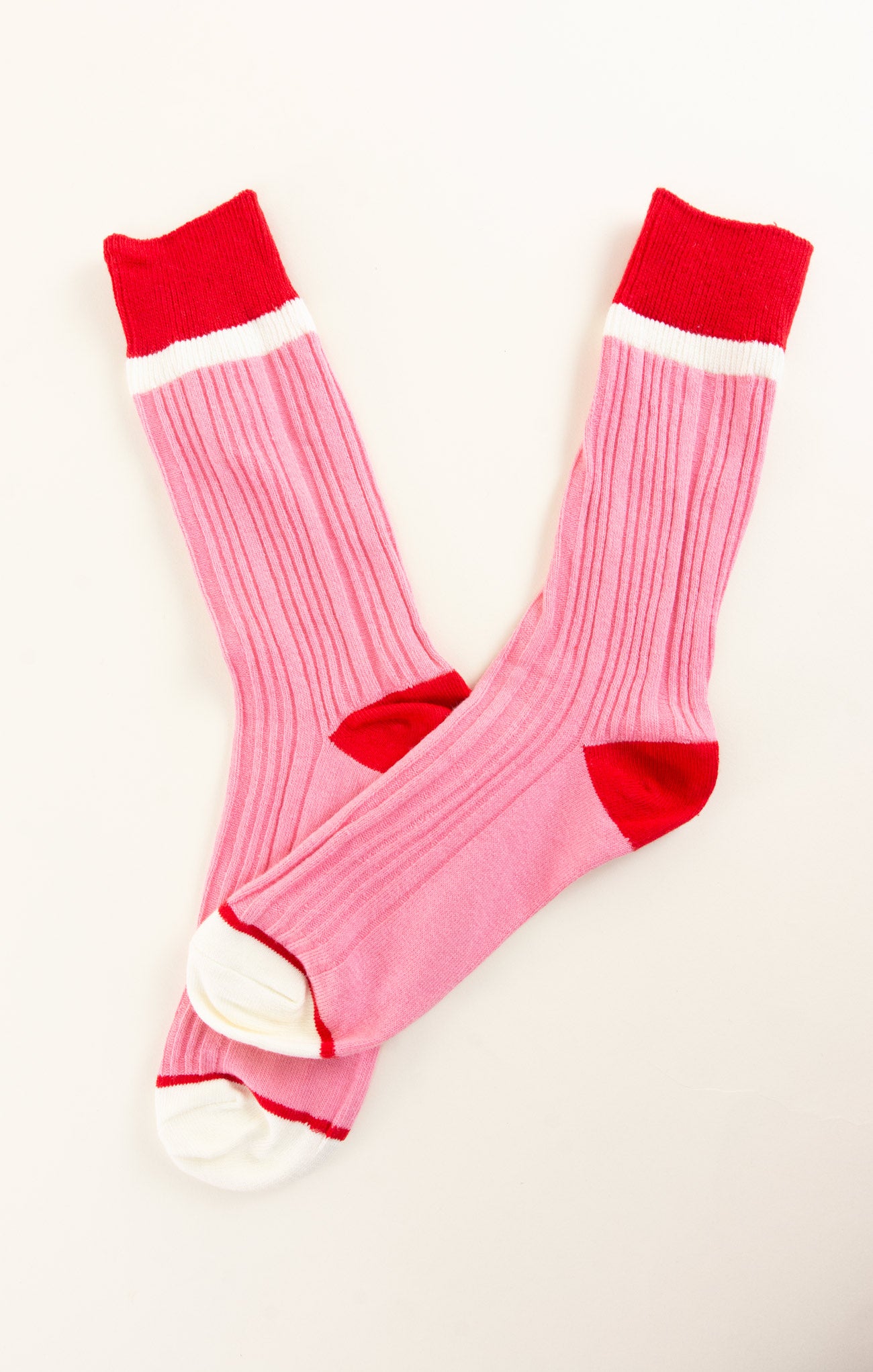 Pink socks with red tops and cuffs on a white background