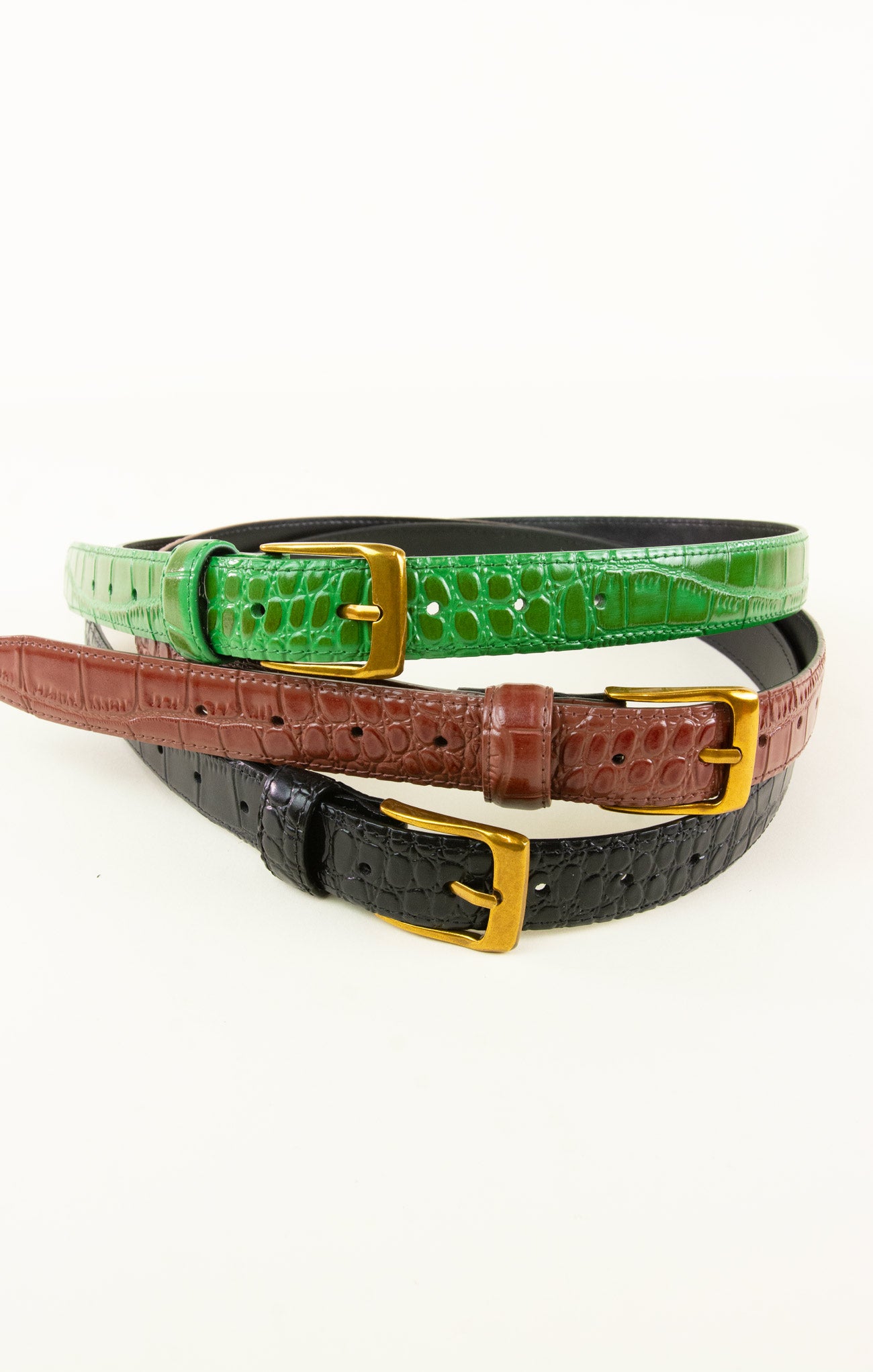 Three belts in green, brown, and black with gold buckles on a white background