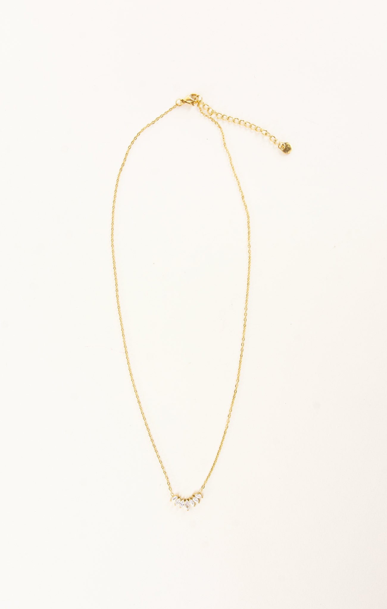 Gold necklace with small pearls on a white background