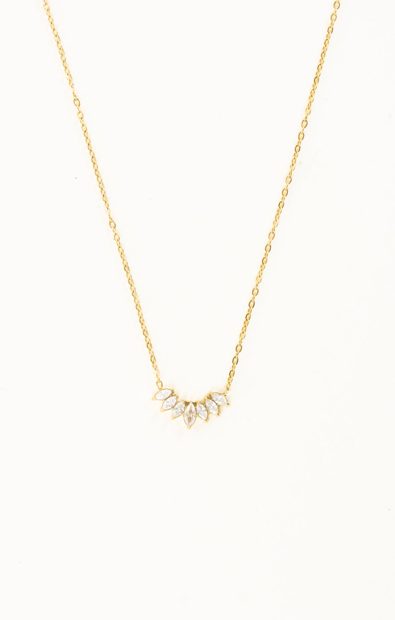 Gold necklace with a small pendant on a white background