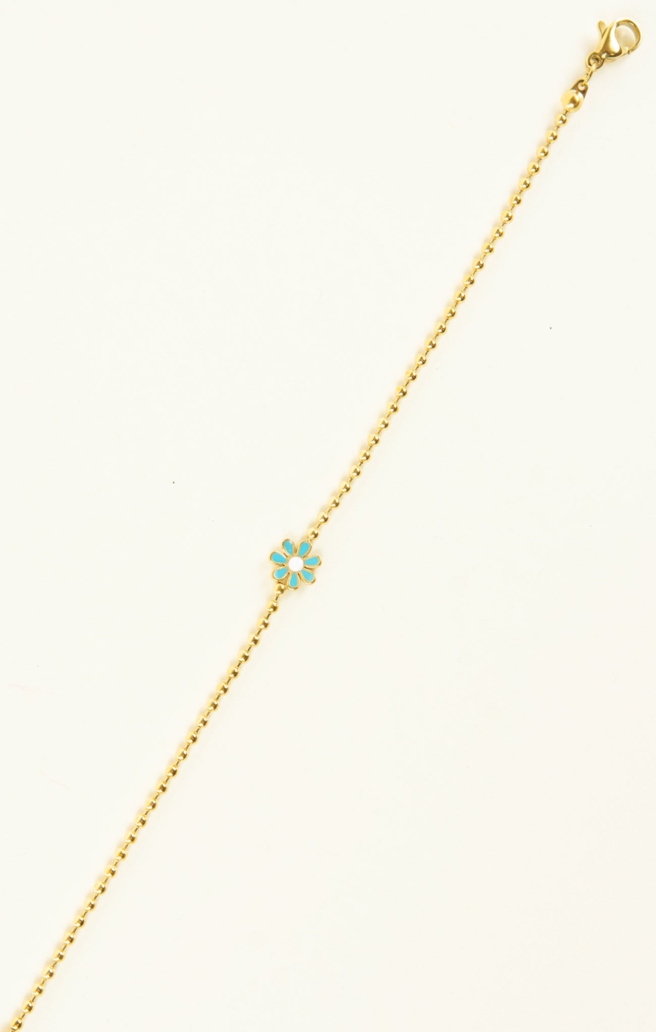 Gold bracelet with a turquoise flower charm on a white background
