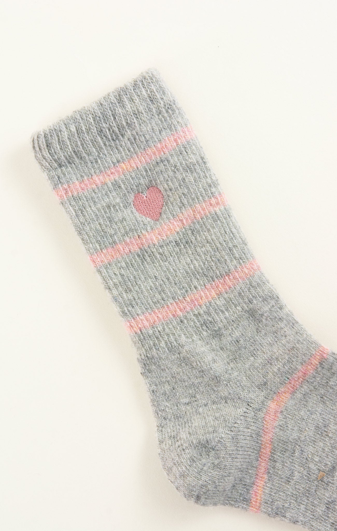 Gray sock with pink heart design and stripes on a white background