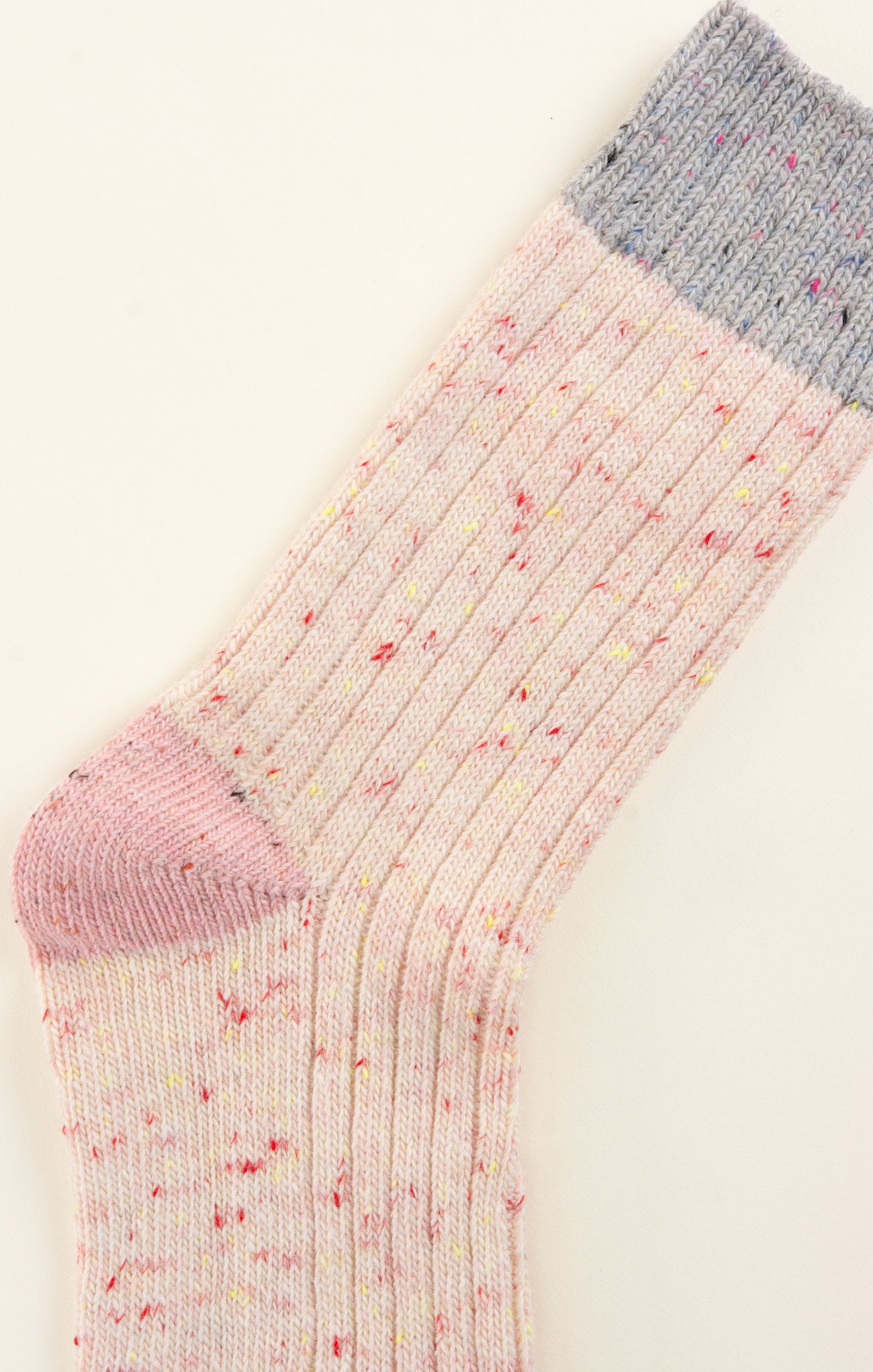 Colorful sock with pink toe and heel on a light background