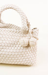 White woven handbag with tassel on a white background