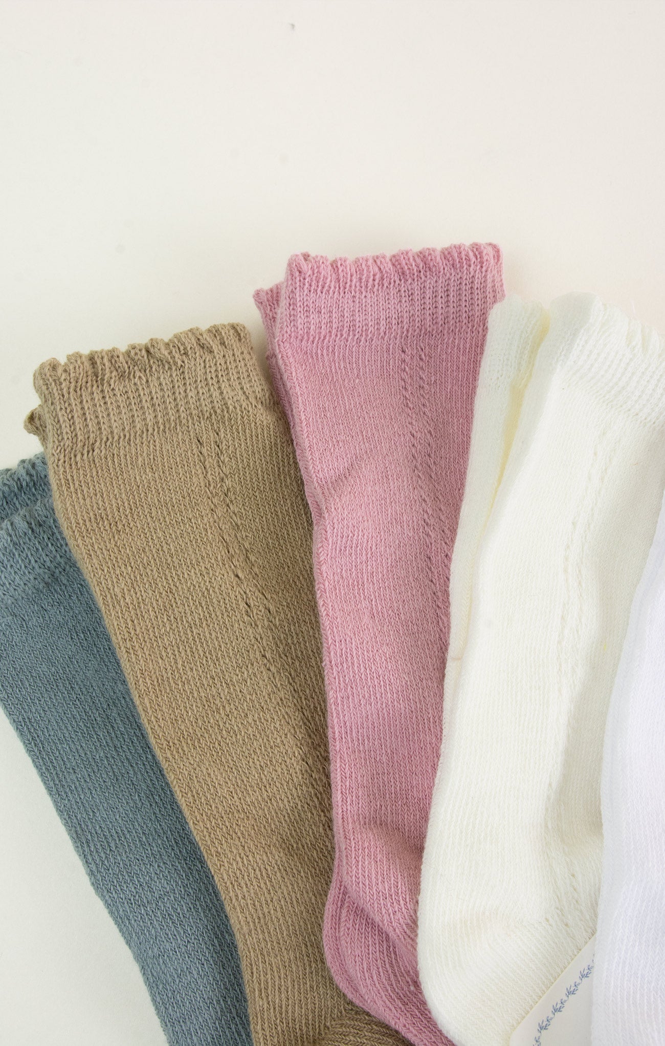 Stack of colorful baby leggings on a light background