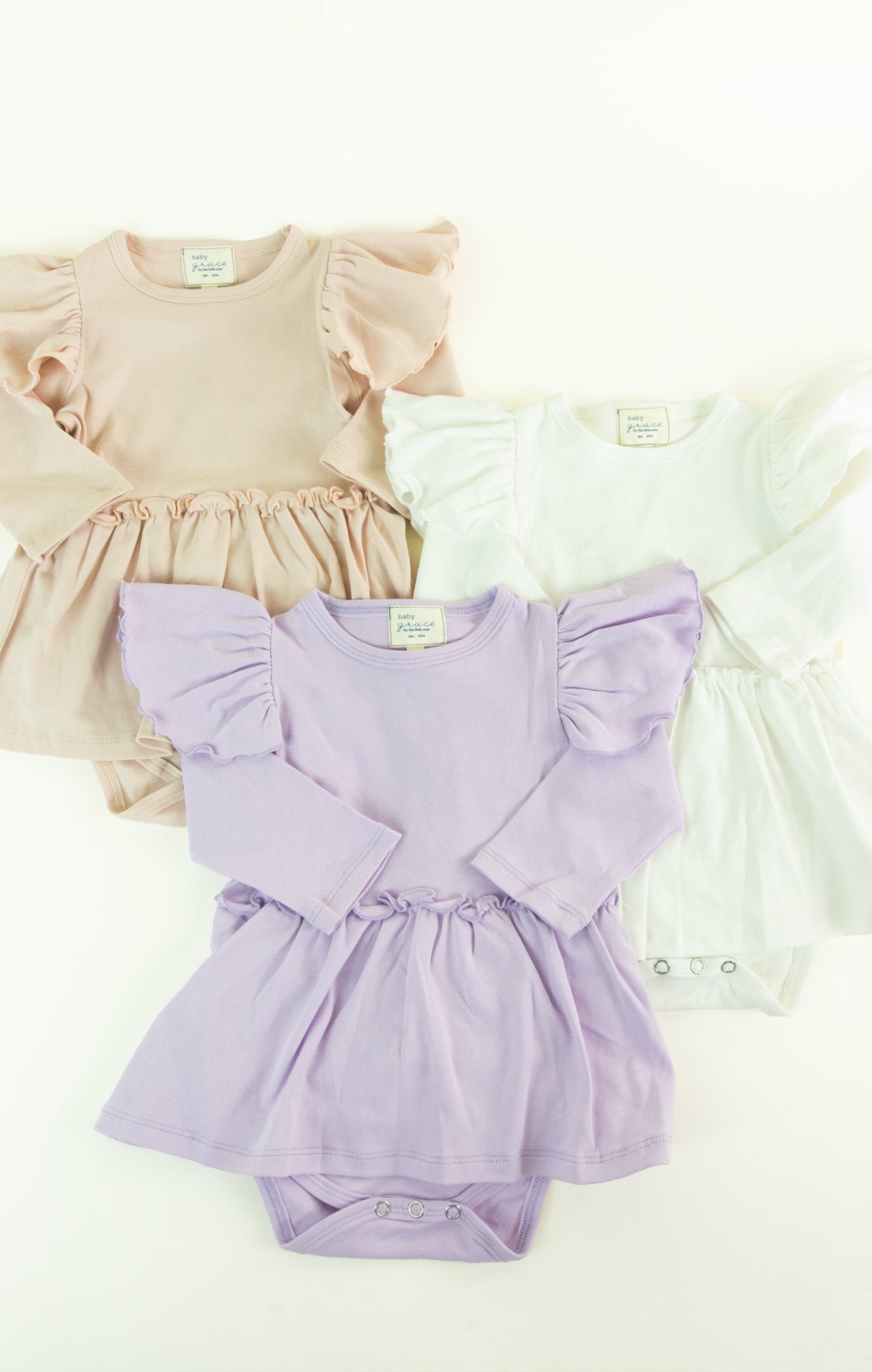 Set of baby rompers in pastel colors on a white background