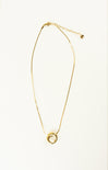 Gold necklace with a circular pendant on a white background