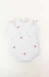 White baby romper with pink floral embroidery on a light beige background