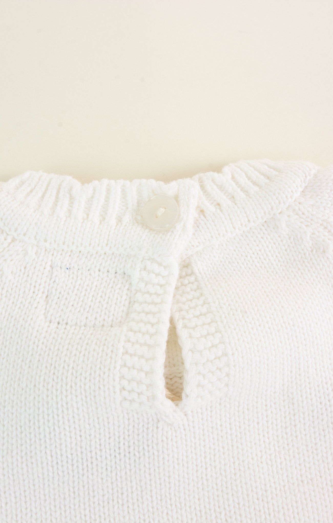 Close-up of a textured white garment on a beige background