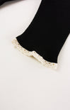 Black sock with lace trim on a white background